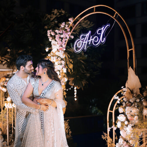 Couple standing under arch with neon lights in the background - neon attack